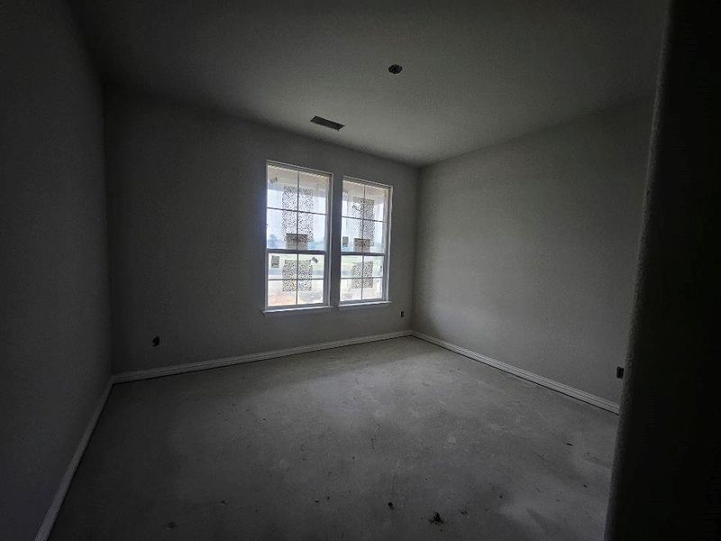 Bright interior space featuring two large windows, white trim, and a high ceiling Bright interior space featuring two large windows, white trim, and a high ceiling