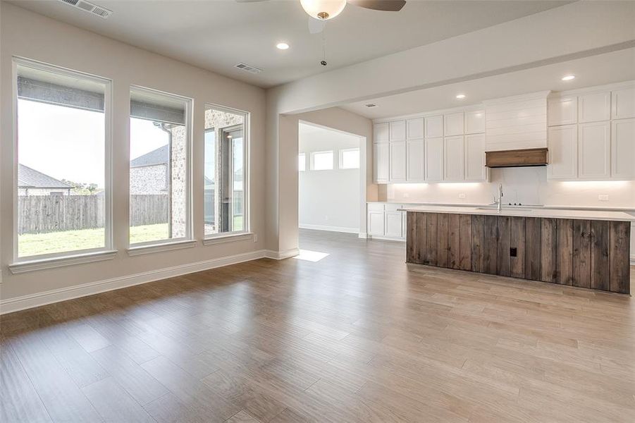 Unfurnished living room featuring light hardwood / wood-style floors, sink, and ceiling fan