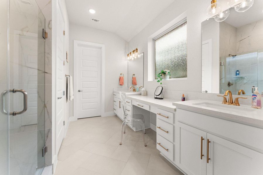The master bathroom has herringbone tile flooring, multi-height vanity with two sinks, a frameless shower with bench, water closet, and rainfall window.
