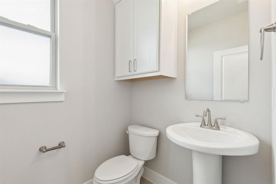 Bathroom featuring toilet and baseboards Bathroom featuring toilet and baseboards