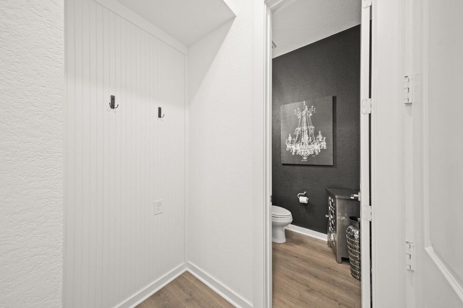 Just across the garage entry is a mudroom area featuring a beadboard accent wall and hooks for backpacks and coats. The three car tandum garage features epoxy flooring.