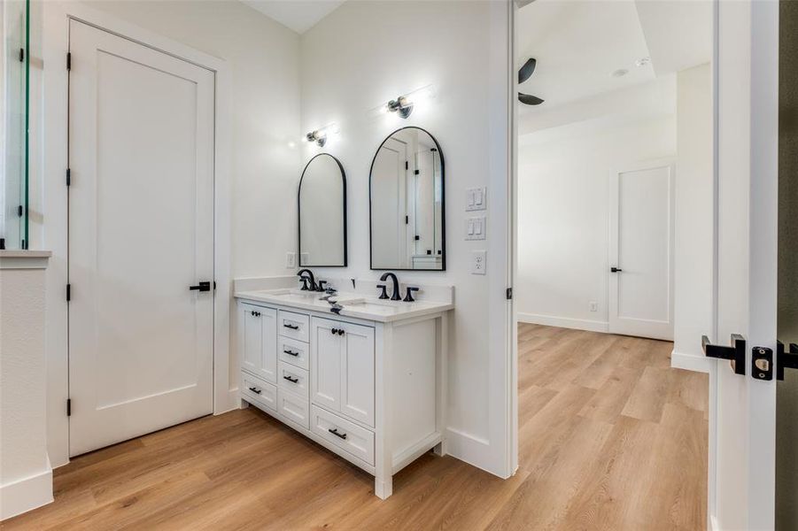Full bathroom with light wood-style flooring, double vanity, and ceiling fan