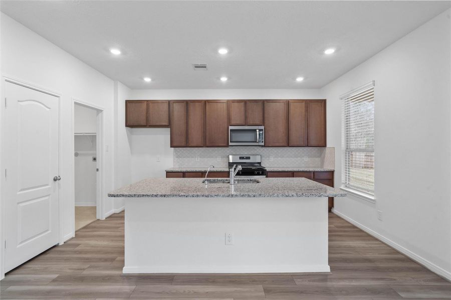 The extended breakfast bar provides additional seating—perfect for a quick meal—while keeping you connected to conversations in both the kitchen and dining area.
