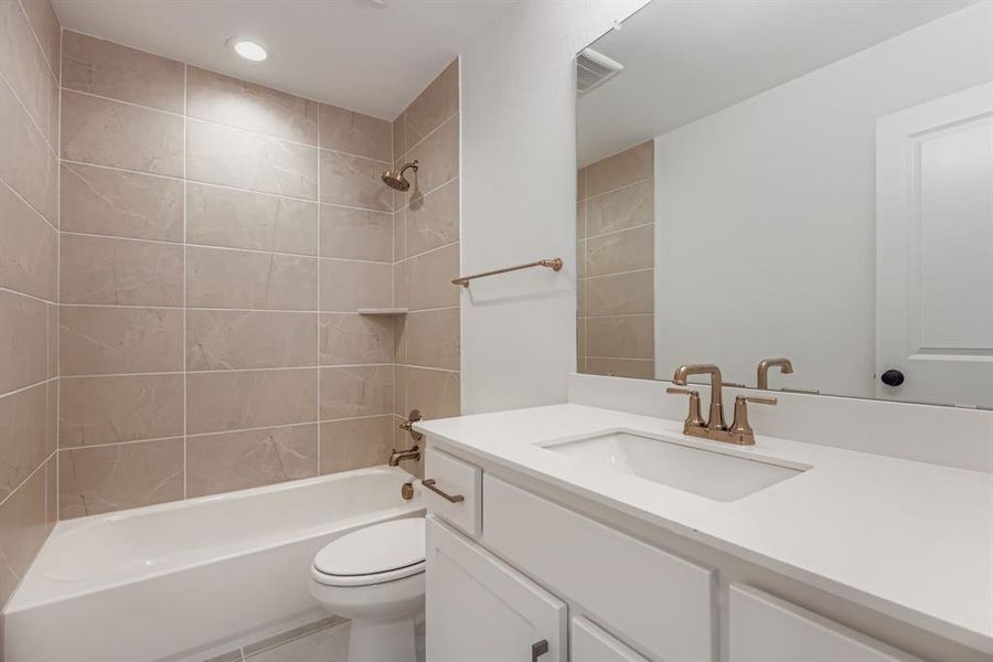 Bathroom featuring tub / shower combination, vanity, and recessed lighting