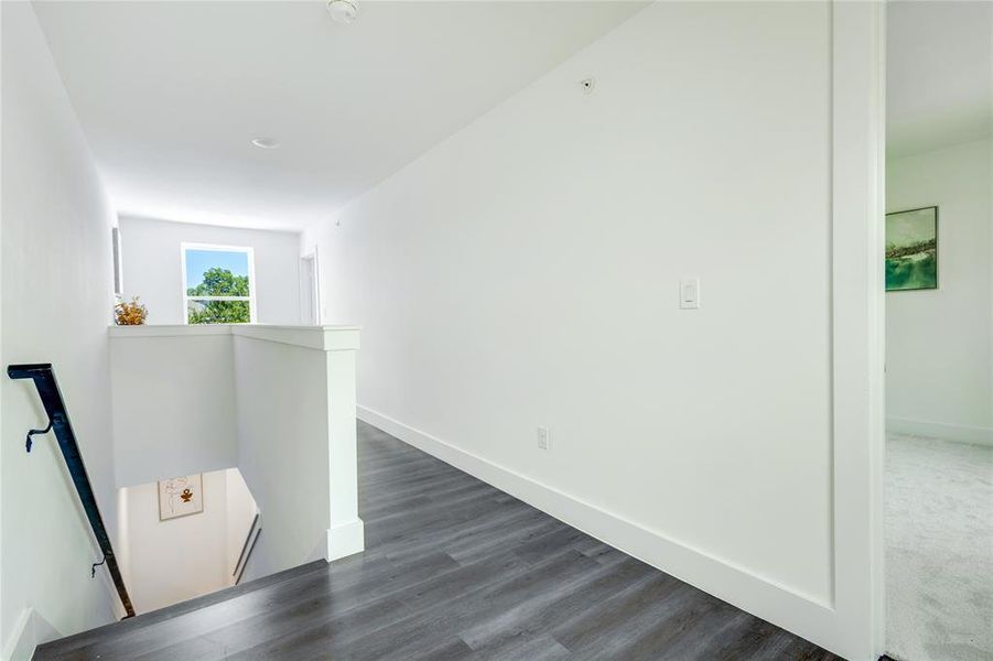 Hallway featuring dark colored carpet