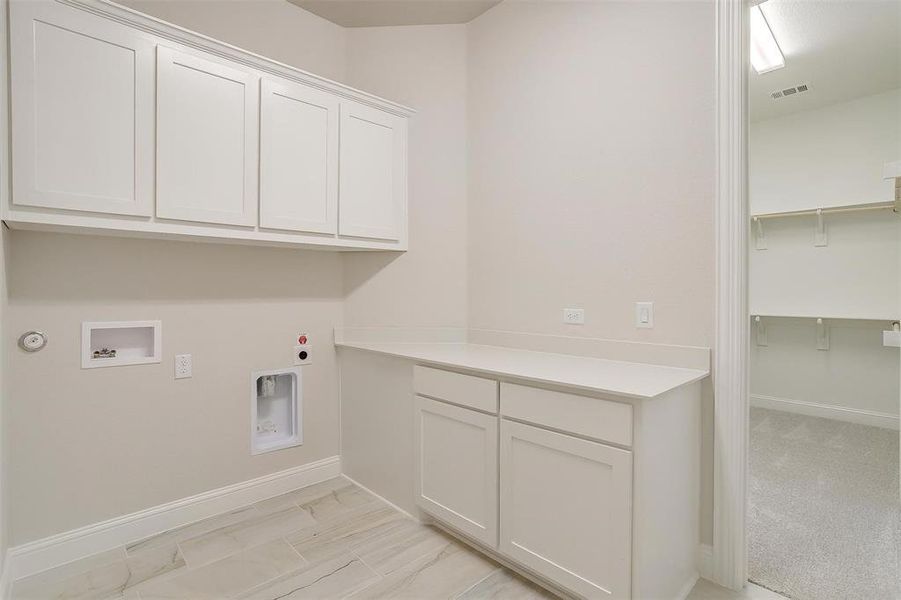 Laundry room featuring cabinets, light colored carpet, hookup for an electric dryer, gas dryer hookup, and washer hookup