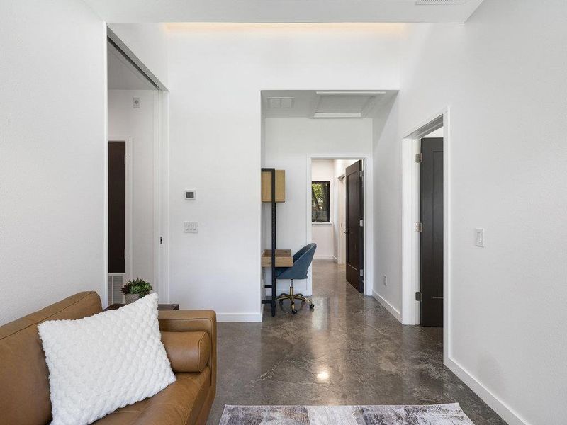 Hallway featuring a desk and baseboards