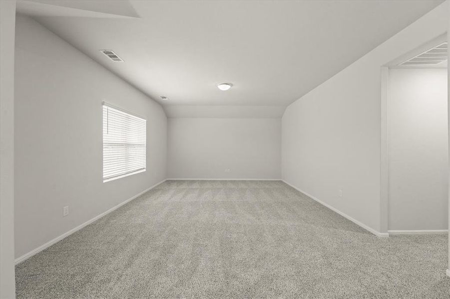 Carpeted empty room with vaulted ceiling