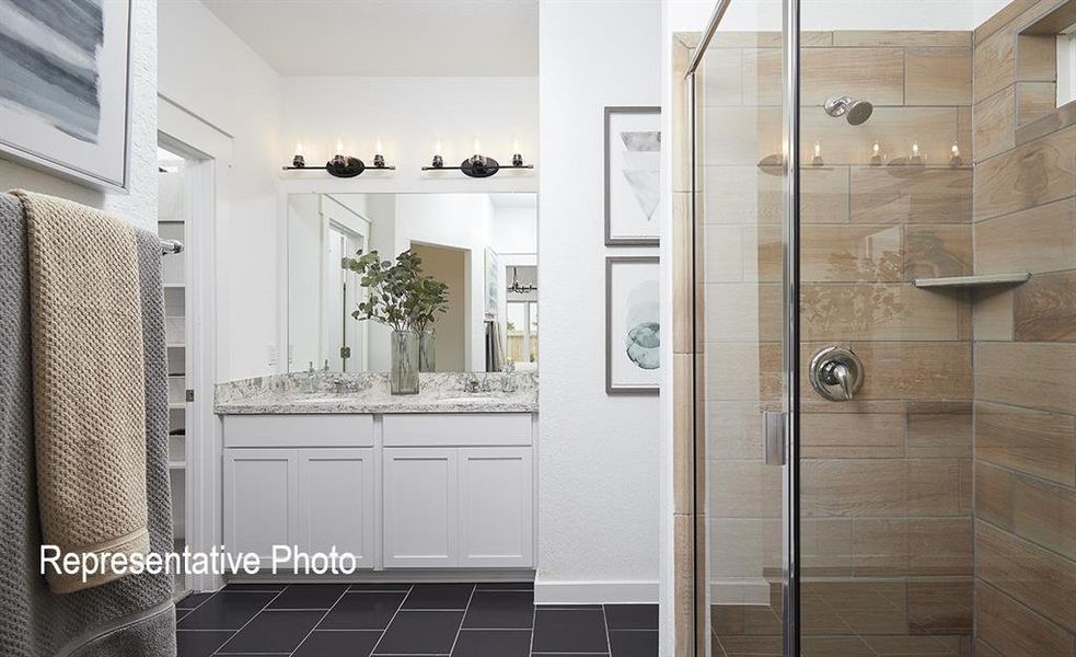 Bathroom with a shower with shower door, vanity, and tile patterned flooring