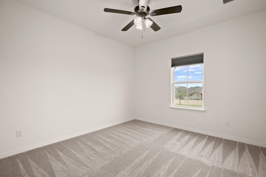 One of three secondary bedrooms upstairs, all with ceiling fans, closet storage, and cozy carpeting. One of three secondary bedrooms upstairs, all with ceiling fans, closet storage, and cozy carpeting.