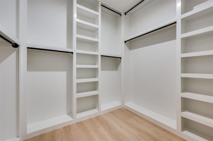 Walk in closet with wood-type flooring