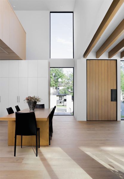 Dining room with light wood-style flooring and healthy amount of natural light