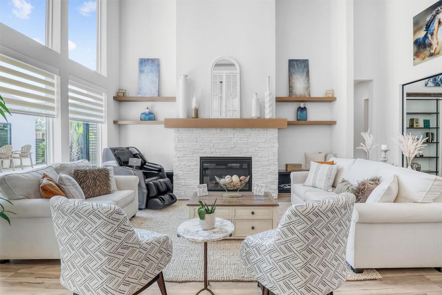 Absolutely breathtaking living room with wall of windows and central fireplace. Snuggle up on the couch with a good book or gather around the fire with family and friends during those cold Texas freezes.