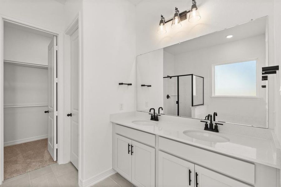 The en-suite bathroom offers a spa-like atmosphere with its elegant design, high end finishes, and tasteful lighting, creating a retreat within your own home.