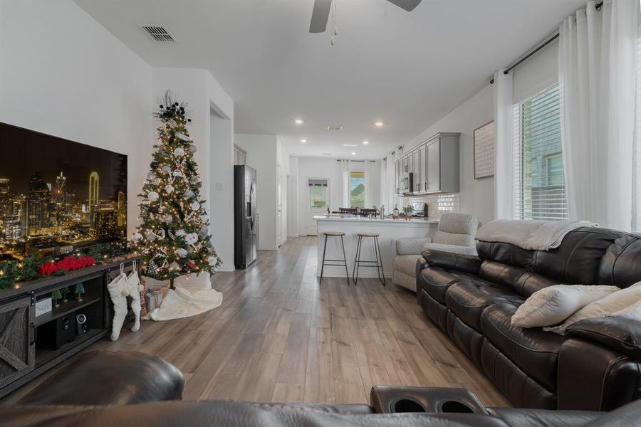 Living room with ceiling fan and light hardwood / wood-style flooring