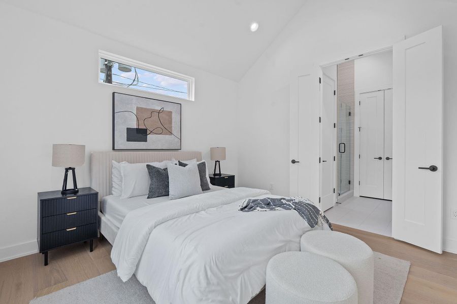 Bedroom with light wood finished floors, lofted ceiling, and recessed lighting