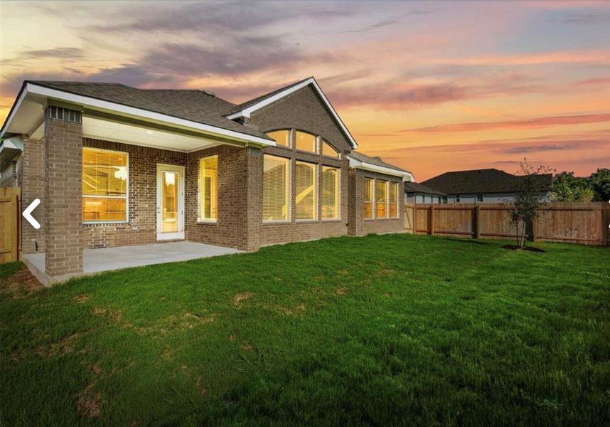 Rear view of property with a fenced backyard, a patio, and brick siding