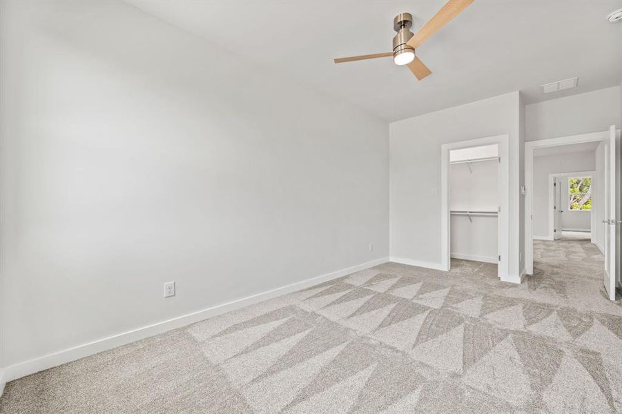 Unfurnished bedroom featuring a closet, ceiling fan, and light colored carpet