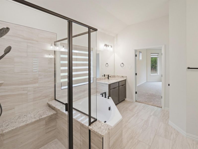 Full bathroom featuring vanity, a shower stall, a bath, and vaulted ceiling