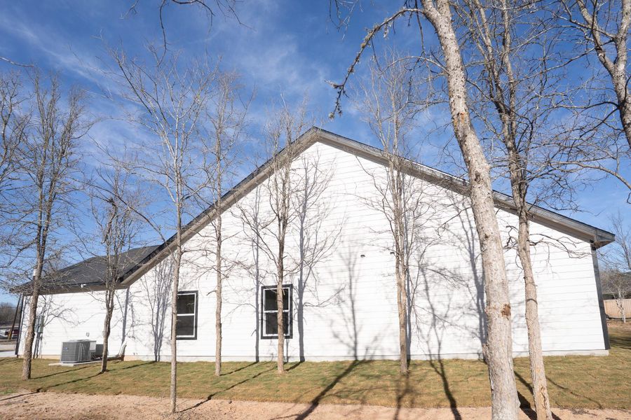 View of home's exterior featuring a yard and a central air condition unit