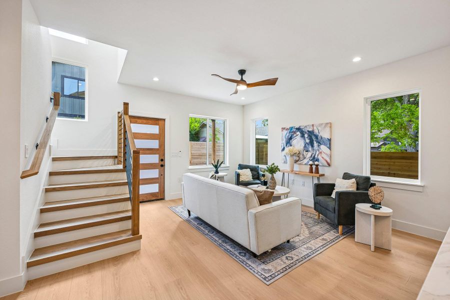 Naturally illuminated living space with high ceilings and light wood-based laminate flooring. Naturally illuminated living space with high ceilings and light wood-based laminate flooring.