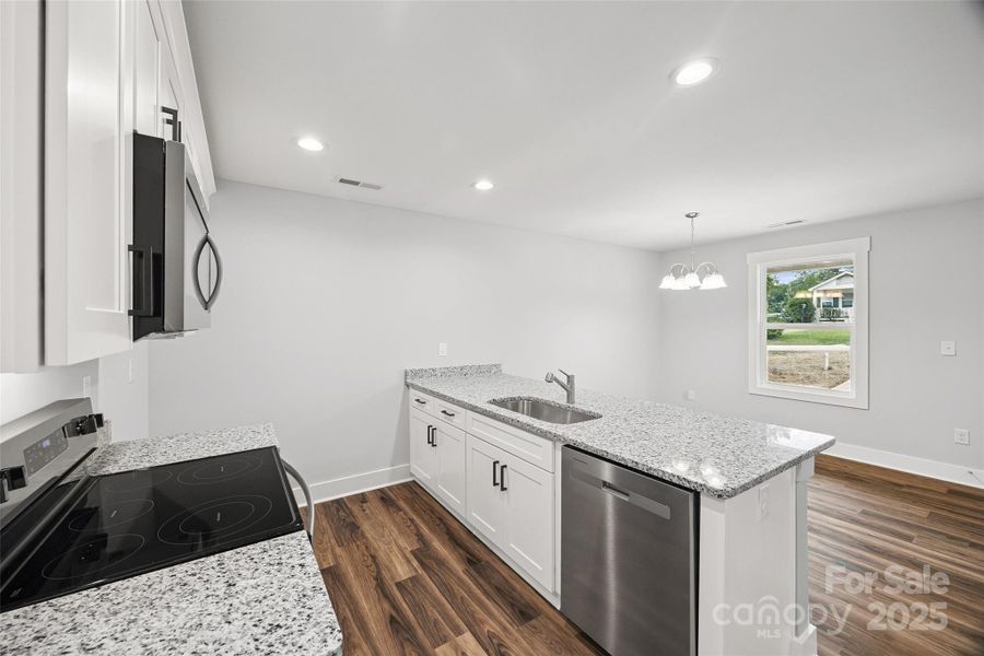 White cabinets, SS appliances, and an island with additional seating