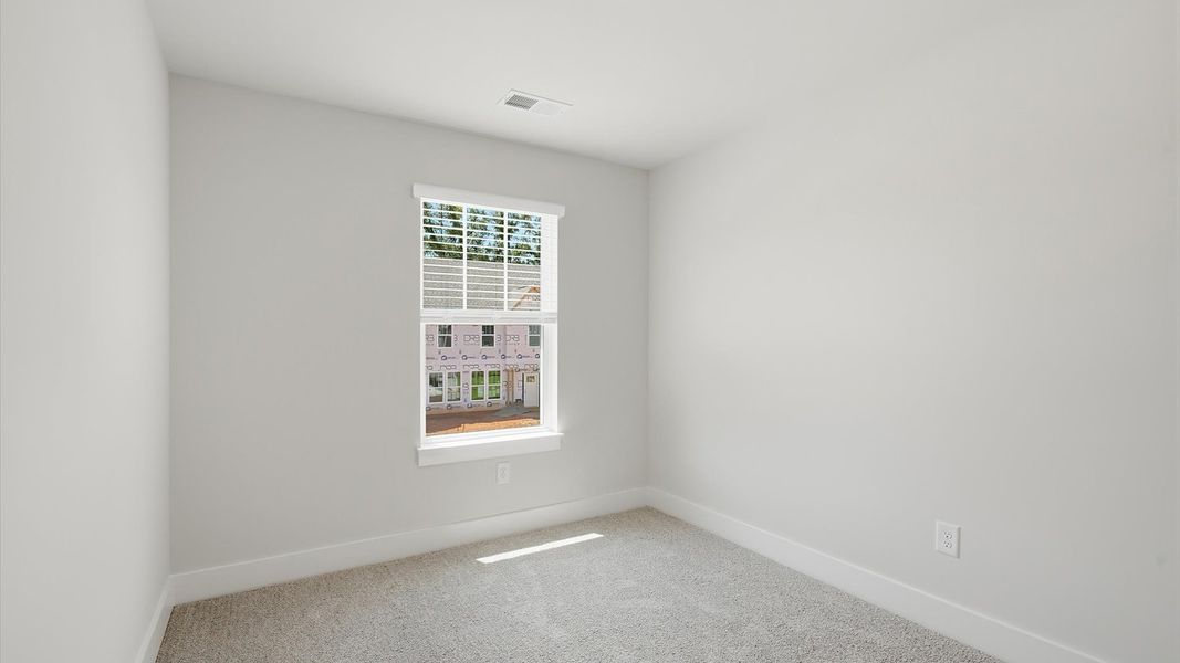 Refined bedroom design with a large window for daylight-filled mornings and peaceful views by DRB Homes