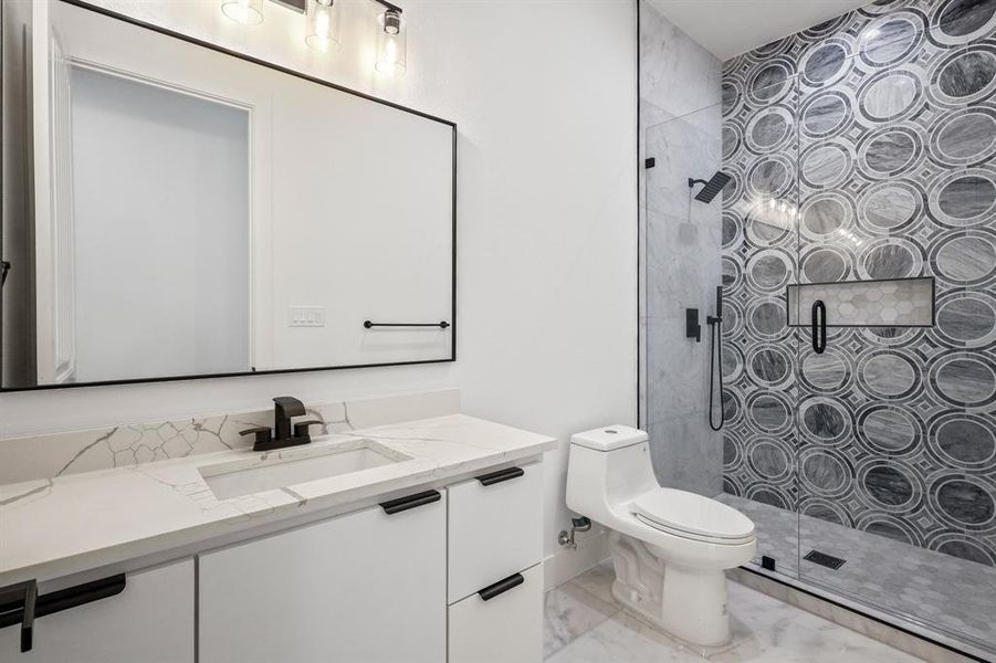 Bathroom featuring tile patterned flooring, an enclosed shower, toilet, and vanity