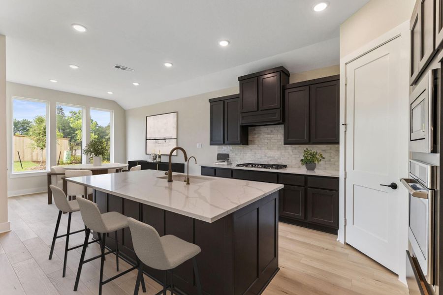 Another view of the kitchen showing the bar area, offering a perfect blend of style and functionality. Another view of the kitchen showing the bar area, offering a perfect blend of style and functionality.