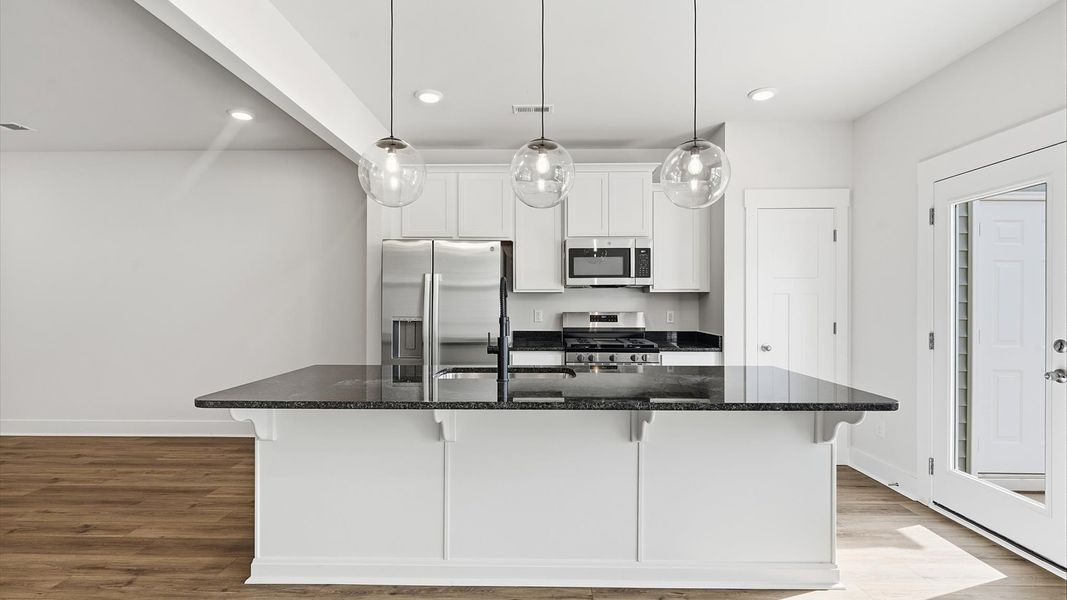 Tasteful kitchen with a streamlined island and modern finishes in a first-class DRB Homes design Tasteful kitchen with a streamlined island and modern finishes in a first-class DRB Homes design