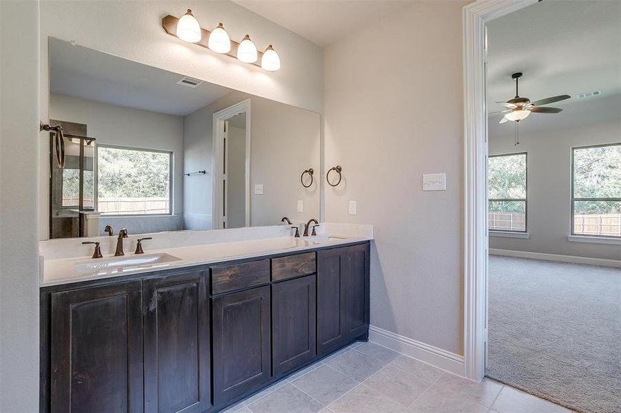 Bathroom featuring vanity, tile patterned flooring, and ceiling fan