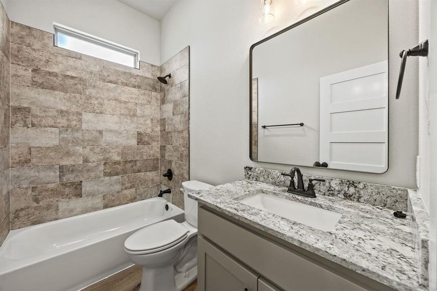 Bathroom with shower / tub combination, vanity, and wood finished floors Bathroom with shower / tub combination, vanity, and wood finished floors