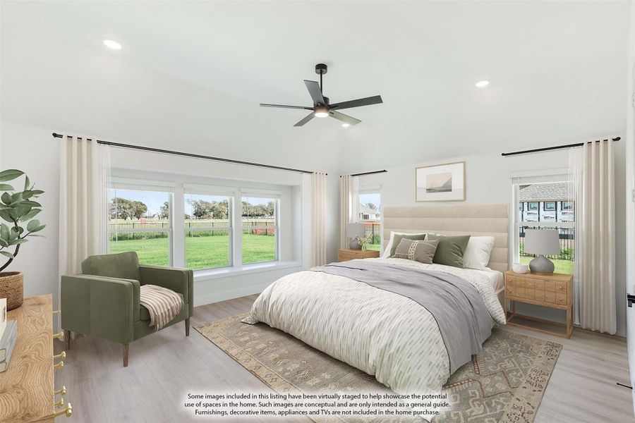 Spacious bedroom with light wood floors, ceiling fan, large windows, and neutral decor including a green accent chair.