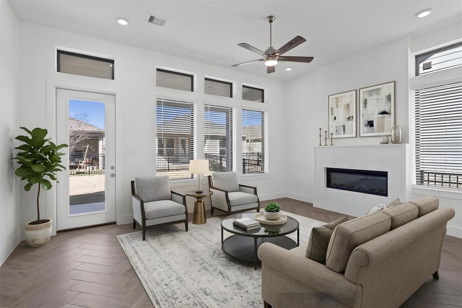 The great room features a fireplace, tall ceilings, ceiling fan, abundant natural light with plenty of windows, and an open, inviting ambiance--perfect for gatherings, relaxation, and making memories. *Virtually Staged