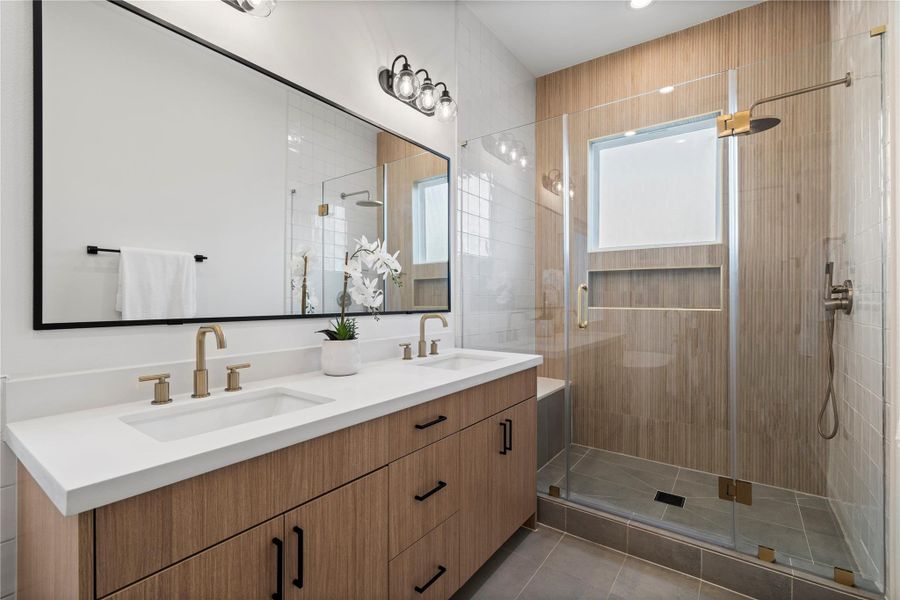 The ensuite features a sleek double vanity with soft-close white oak cabinetry and a spacious frameless walk-in shower, blending modern elegance with everyday functionality.