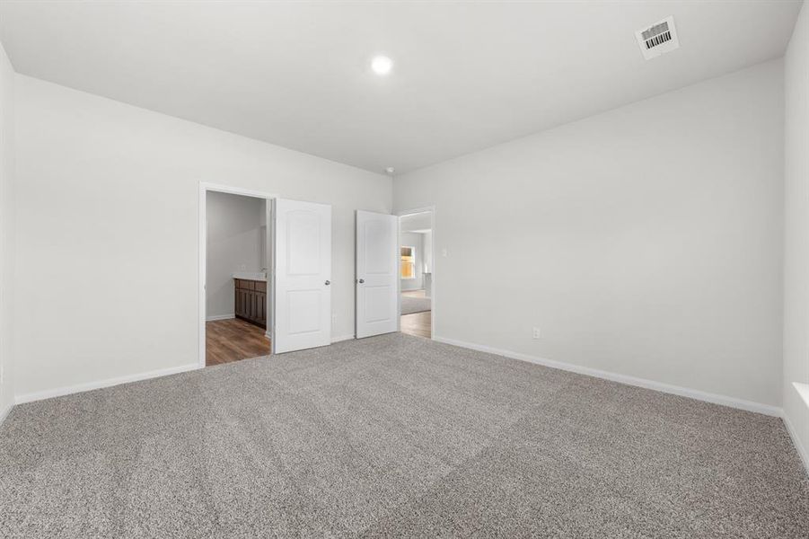 Unfurnished bedroom with carpet flooring and connected bathroom