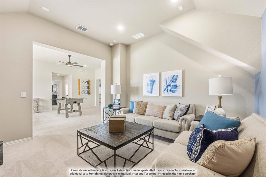 Living room with vaulted ceiling, sectional sofa, and open view to game room with foosball table
