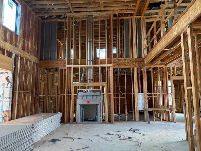 Spacious interior under construction, showcasing high ceilings and framed walls with ample natural light from large windows. Spacious interior under construction, showcasing high ceilings and framed walls with ample natural light from large windows.