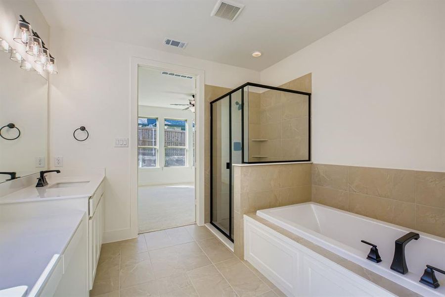 Bathroom with vanity, a garden tub, a stall shower, and light tile patterned floors