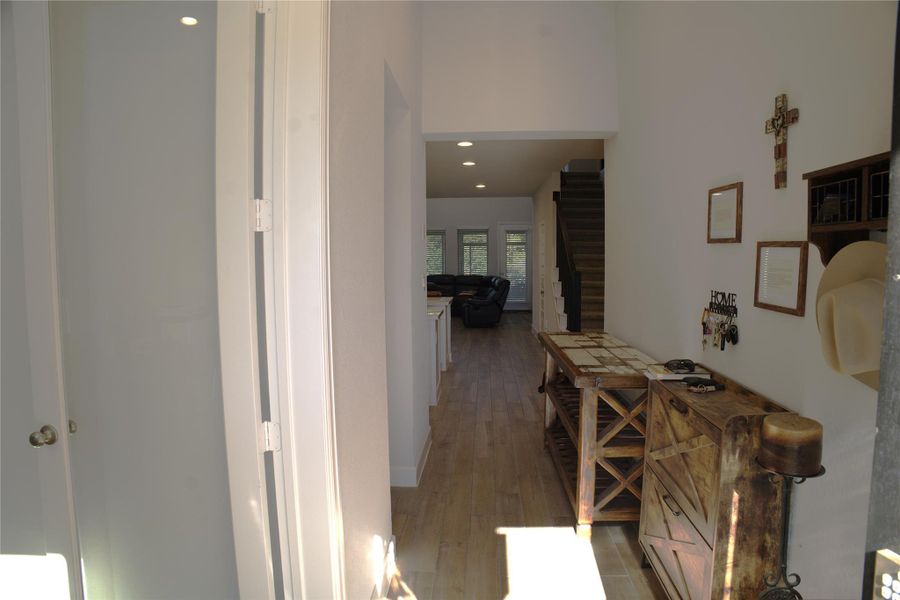 Hallway featuring wood finished floors, recessed lighting, and stairway Hallway featuring wood finished floors, recessed lighting, and stairway