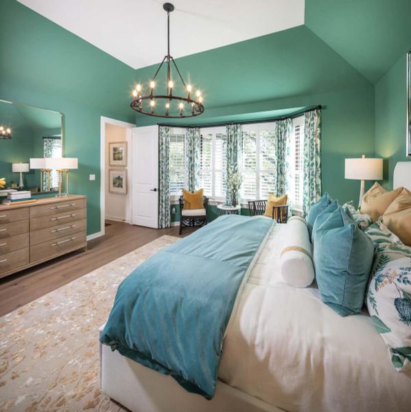 Bedroom with vaulted ceiling, wood finished floors, baseboards, and a chandelier