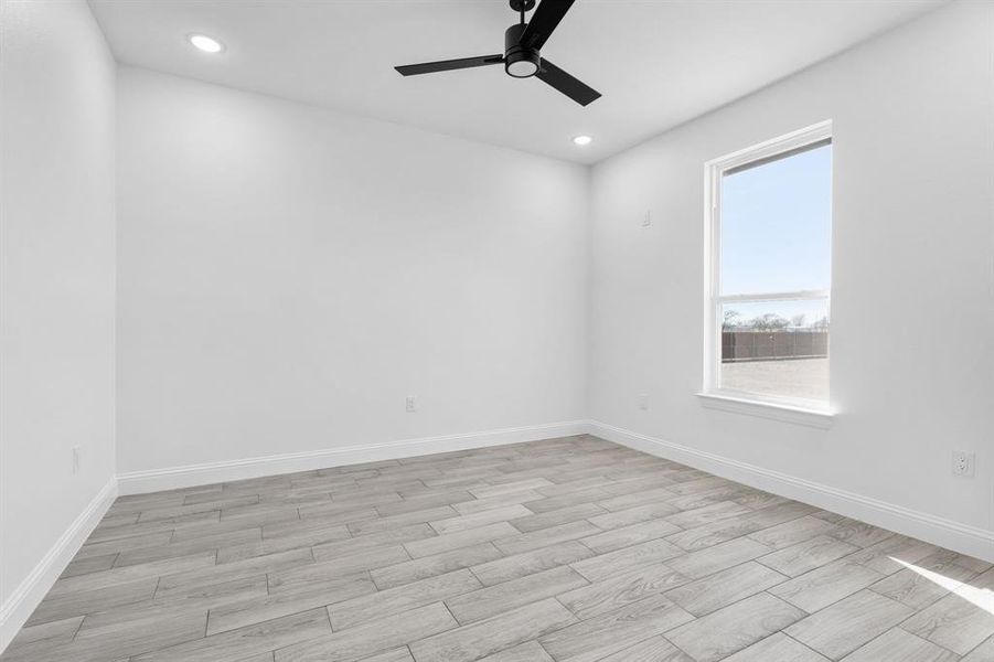 Spare room with ceiling fan and light hardwood / wood-style floors