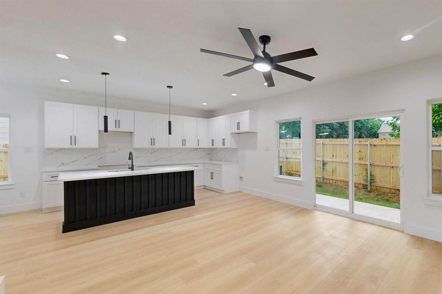 Kitchen with plenty of natural light, tasteful backsplash, white cabinetry, and recessed lighting Kitchen with plenty of natural light, tasteful backsplash, white cabinetry, and recessed lighting