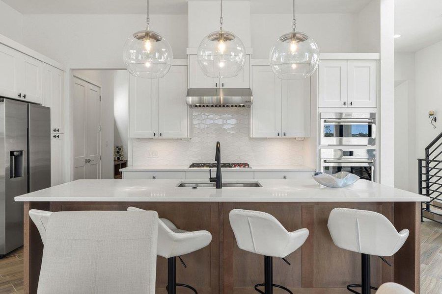 Kitchen island featuring a white countertop, wood-finish base, and integrated sink