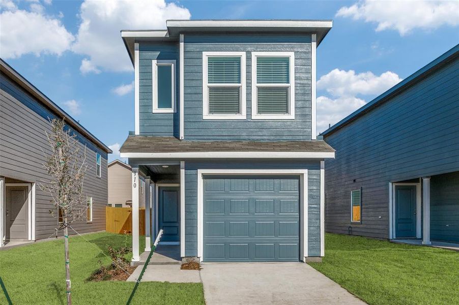 View of front of house featuring a garage and a front yard
