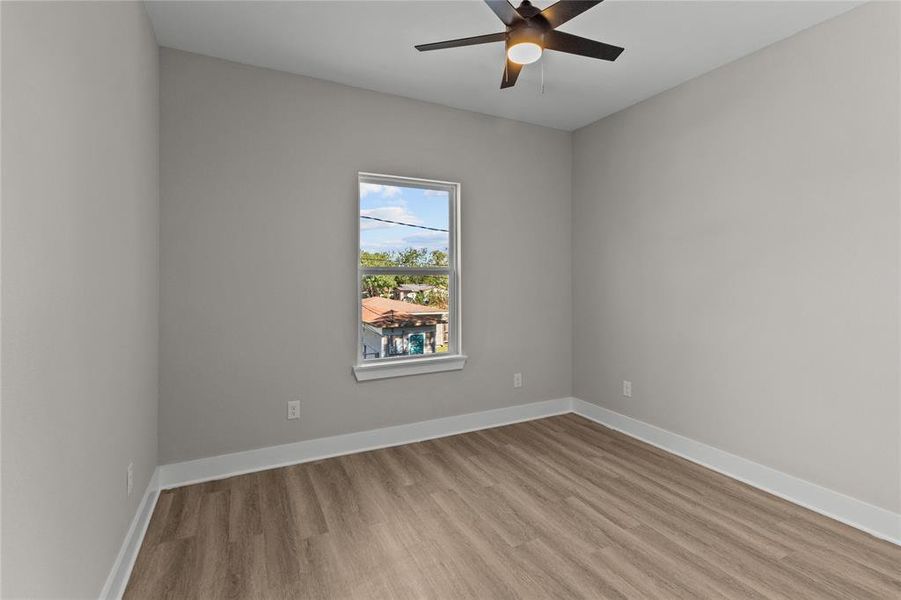 This first secondary bedroom overlooks the peaceful backyard, providing a relaxing retreat for guests or family.