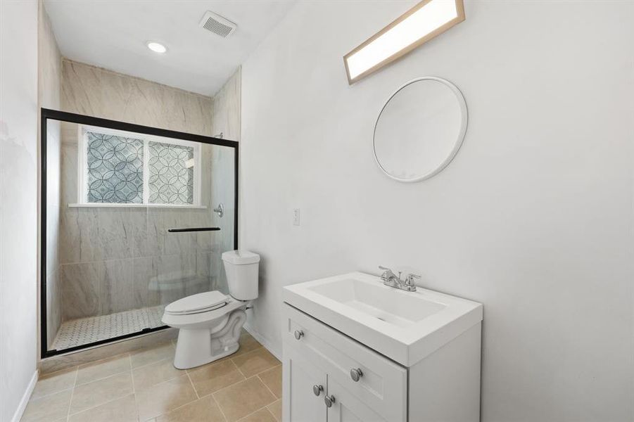 Full bathroom featuring vanity, light tile patterned floors, and an oversized shower