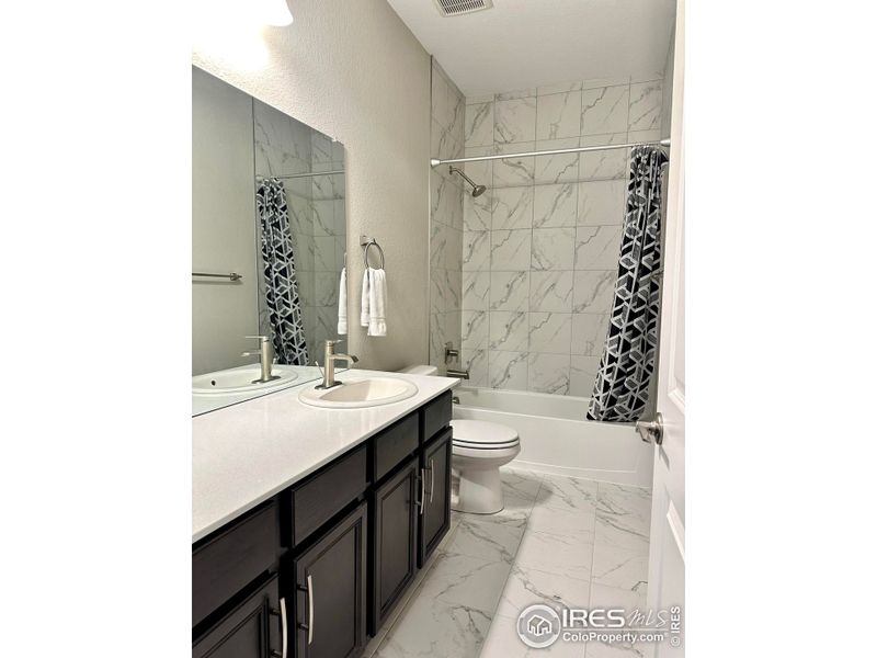 Large hall bathroom with oversized vanity and tile floors