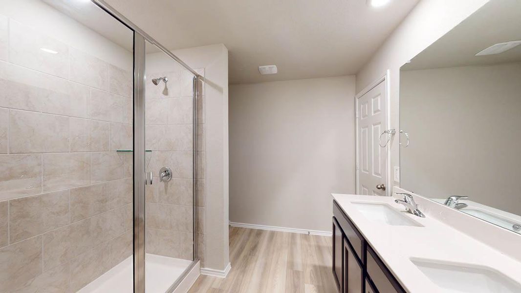A well-appointed bath features a spacious tiled shower and a sleek double vanity. A well-appointed bath features a spacious tiled shower and a sleek double vanity.