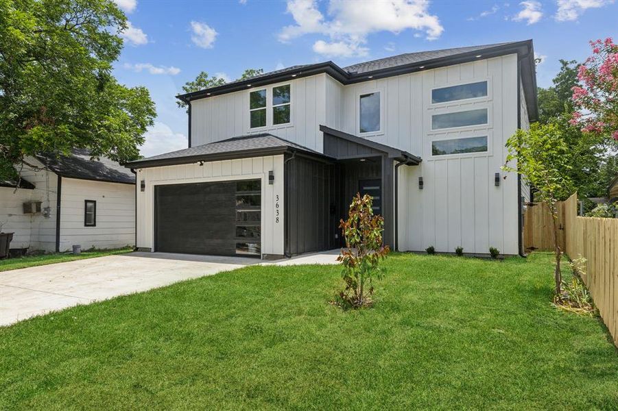 View of front of house featuring a garage and a front lawn